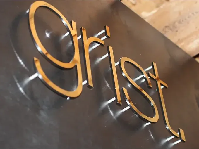 grist. dimensional metal signage installed by ninety two