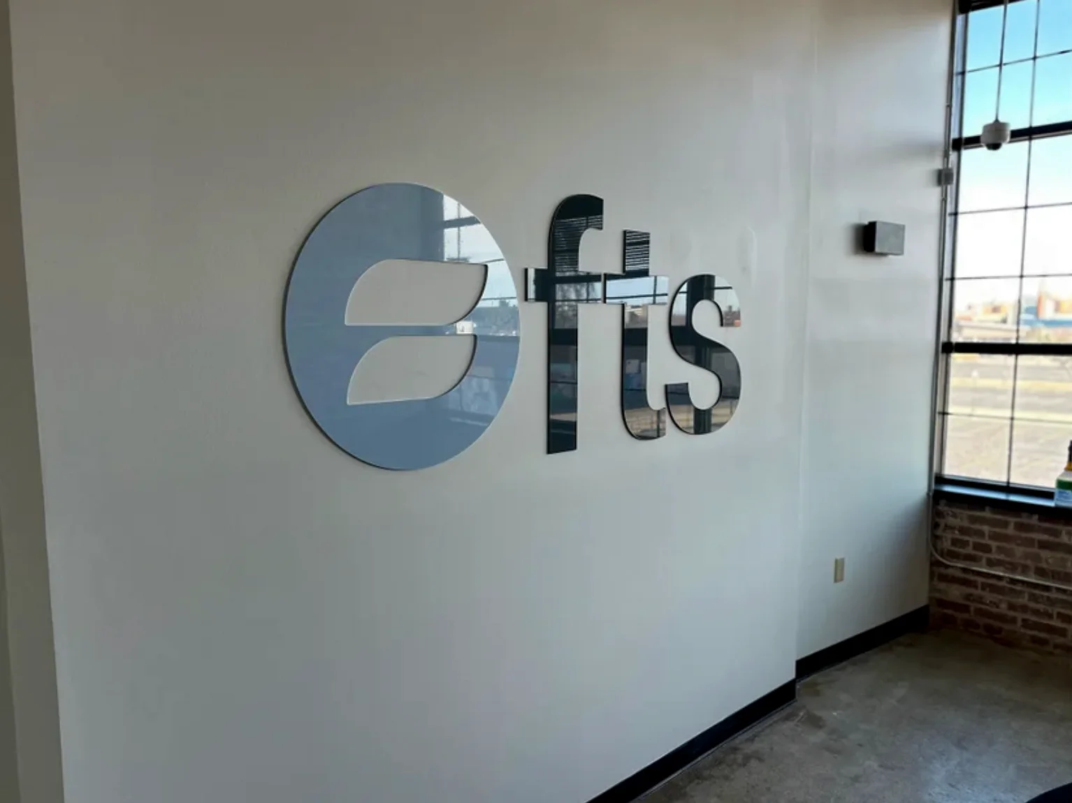 FTS Business Consultants dimensional acrylic wall signage installed in workplace